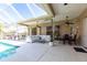 Spacious covered patio with lounge area, dining set, and seamless access to the screened pool at 4822 Hamlets Grove Dr, Sarasota, FL 34235