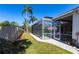 Well-maintained backyard with a sparkling screened-in pool, palm trees, and manicured landscaping at 4822 Hamlets Grove Dr, Sarasota, FL 34235