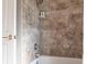 A close-up of a bathtub and shower area, featuring neutral tile and modern fixtures at 4822 Hamlets Grove Dr, Sarasota, FL 34235