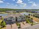 Aerial view of townhomes on a lake with mature landscaping, sidewalks, and a gazebo on the waterfront at 4828 San Martino Dr, Wesley Chapel, FL 33543