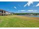 Wide view of a large manicured backyard leading to a serene lake surrounded by natural Florida landscape at 4828 San Martino Dr, Wesley Chapel, FL 33543