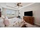 Spacious bedroom with a trey ceiling, large TV, and natural light from the window at 4828 San Martino Dr, Wesley Chapel, FL 33543