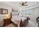 Bright bedroom with a decorative bed frame, tray ceiling and two windows offering a relaxing retreat at 4828 San Martino Dr, Wesley Chapel, FL 33543