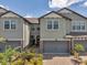 View of a well-maintained townhome exterior with two-car garages, brick driveways and lush front yard landscaping at 4828 San Martino Dr, Wesley Chapel, FL 33543