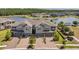 An eye-level view of three elegant townhomes with brick driveways, two-car garages and lush green landscaping at 4828 San Martino Dr, Wesley Chapel, FL 33543