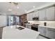 Modern kitchen boasts stainless steel appliances, light gray cabinets, a center island with an accent wall in view at 4828 San Martino Dr, Wesley Chapel, FL 33543