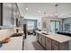 Stylish kitchen showcasing a center island, gray cabinetry, stainless steel appliances and opens to the Gathering and office spaces at 4828 San Martino Dr, Wesley Chapel, FL 33543