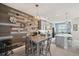Well-lit kitchen with stainless steel appliances, unique wooden accent wall, and a modern dining area at 4828 San Martino Dr, Wesley Chapel, FL 33543