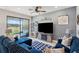 Beautiful living room with blue sectional, stylish rug, and sliding glass doors to the outdoor patio at 4828 San Martino Dr, Wesley Chapel, FL 33543
