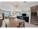 Open-concept living room featuring modern lighting, sleek tile flooring, and a comfortable seating area at 4828 San Martino Dr, Wesley Chapel, FL 33543