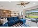 Bright living room features a blue sectional, stylish rug and sliding glass doors with a view to the backyard at 4828 San Martino Dr, Wesley Chapel, FL 33543