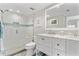 Bright bathroom featuring a glass-enclosed shower with custom tile work, white vanity, and modern fixtures at 4900 Brittany S Dr # 811, St Petersburg, FL 33715