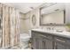 Bathroom with decorative shower curtain, large mirror, and a modern vanity at 4900 Brittany S Dr # 811, St Petersburg, FL 33715