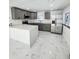 Modern kitchen boasts gray cabinets, stainless steel appliances, and an island with white quartz countertops at 547 16Th S Ave, St Petersburg, FL 33701