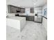 Modern kitchen boasts gray cabinets, stainless steel appliances, and an island with white quartz countertops at 547 16Th S Ave, St Petersburg, FL 33701