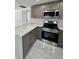 Modern kitchen with gray cabinets, stainless steel appliances, and white quartz countertops at 547 16Th S Ave, St Petersburg, FL 33701