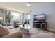 Bright living room with a flat screen TV, plush seating, and sliding glass doors to the balcony at 6287 Bahia Del Mar Cir # 801, St Petersburg, FL 33715