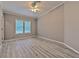 Well-lit bedroom with wood-look flooring, ceiling fan, and large windows at 6633 Applewood Dr, Wesley Chapel, FL 33544