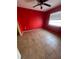 Empty bedroom with red walls, tile flooring, a window with blinds, and a ceiling fan at 7421 Mulligan Ct, Port Richey, FL 34668