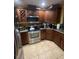 A kitchen featuring stainless steel appliances, dark wood cabinetry, and granite countertops at 7421 Mulligan Ct, Port Richey, FL 34668