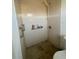Tiled shower stall with a showerhead, grab bars, and a shelf holding bath products at 7421 Mulligan Ct, Port Richey, FL 34668