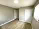A spacious bedroom with wood-look tile flooring, light grey walls, and double door closet at 8310 Croton Ave, Tampa, FL 33619