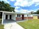 Charming single-story home featuring a carport, brick accents, and a well-maintained front lawn at 8310 Croton Ave, Tampa, FL 33619