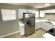 A modern kitchen showcasing stainless steel refrigerator, white cabinets, and wood-look floors at 8310 Croton Ave, Tampa, FL 33619