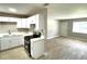 A bright kitchen featuring white cabinets, stainless steel appliances, and a view to the living area at 8310 Croton Ave, Tampa, FL 33619