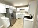 A bright kitchen featuring white cabinets, stainless steel appliances, and tile flooring at 8310 Croton Ave, Tampa, FL 33619