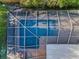 Aerial view of screened pool with a brick paver deck and updated screening at 833 Lakeside Ter, Palm Harbor, FL 34683