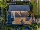 Aerial view of the home with a screened-in pool and patio area, surrounded by lush landscaping at 833 Lakeside Ter, Palm Harbor, FL 34683