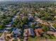 Aerial view of a neighborhood showcasing lush greenery and residential homes on a sunny day at 833 Lakeside Ter, Palm Harbor, FL 34683