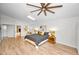 Light-filled bedroom boasts neutral walls, wood floors, and ceiling fan at 833 Lakeside Ter, Palm Harbor, FL 34683