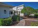 Charming home featuring a stone pillar walkway, lush landscaping, and mature trees at 833 Lakeside Ter, Palm Harbor, FL 34683
