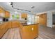 An open-concept kitchen with wooden cabinets, an island, and large windows, providing ample natural light and space at 833 Lakeside Ter, Palm Harbor, FL 34683