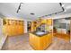 Large kitchen with wooden cabinetry, stone fireplace and kitchen island, with an open floor plan to the rest of the house at 833 Lakeside Ter, Palm Harbor, FL 34683