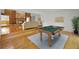 A bright living area with a fireplace, hardwood flooring, and a pool table, creating an inviting space at 833 Lakeside Ter, Palm Harbor, FL 34683