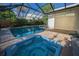 A screened-in pool and attached hot tub with brick pavers is ideal for relaxation at 833 Lakeside Ter, Palm Harbor, FL 34683