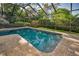 Screened pool with brick paver deck offers a refreshing outdoor oasis, surrounded by mature landscaping at 833 Lakeside Ter, Palm Harbor, FL 34683