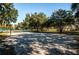 Sandy volleyball court ready for a game, shaded by mature trees in a green space at 833 Lakeside Ter, Palm Harbor, FL 34683