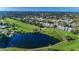 An aerial view of a townhome community on a golf course with a large pond at 9050 Park Blvd # 5, Seminole, FL 33777