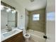Updated bathroom featuring modern vanity, brushed nickel fixtures, and tub with tiled shower at 9230 Wood Dr, Hudson, FL 34667