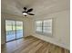 Bedroom featuring hardwood flooring, ceiling fan and sliding glass doors to covered outdoor area at 9230 Wood Dr, Hudson, FL 34667