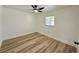 Comfortable bedroom featuring light-colored hardwood floors, ceiling fan, and a window for natural light at 9230 Wood Dr, Hudson, FL 34667