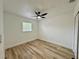 Bright bedroom with sleek hardwood flooring, a ceiling fan, and a window for natural light at 9230 Wood Dr, Hudson, FL 34667