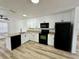 Modern kitchen featuring granite countertops, white cabinets and sleek, black appliances at 9230 Wood Dr, Hudson, FL 34667