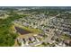 A high aerial view of a suburban neighborhood featuring well-maintained lawns and a small lake nearby at 10013 Caraway Spice Ave, Riverview, FL 33578