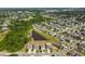 Aerial view of homes with a pond surrounded by green trees in a well-maintained suburban neighborhood at 10013 Caraway Spice Ave, Riverview, FL 33578