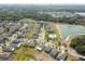 Wide aerial view of neighborhood with community pool, lake, green landscaping, and modern homes at 10013 Caraway Spice Ave, Riverview, FL 33578